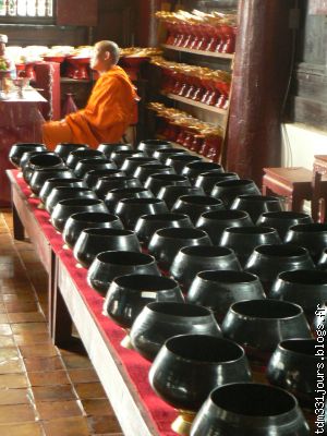 bols a offrandes et moine a l'interieur du temple